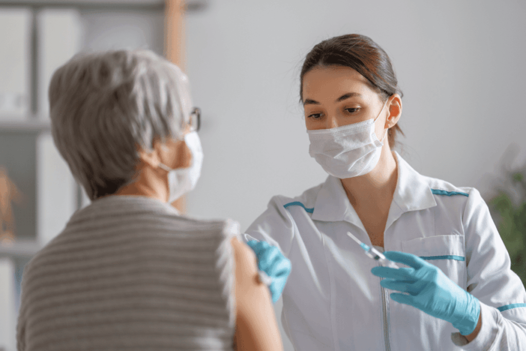 A healthcare professional prepares to give a mature patient an injection. 