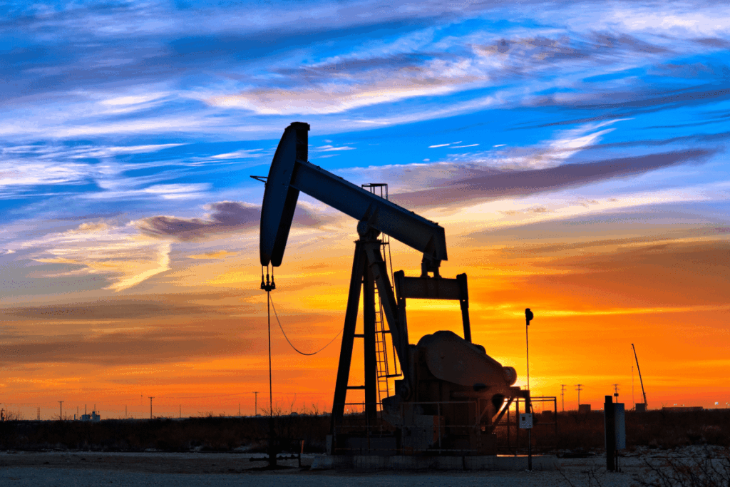 An oil pumpjack silhouetted against a colorful sunset in the Permian Basin. 