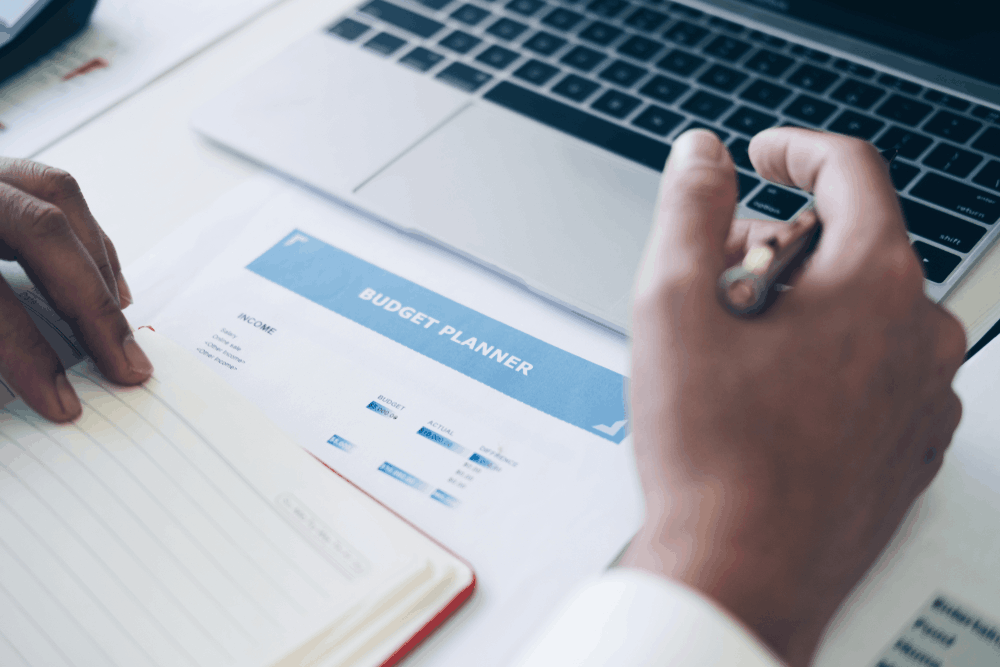 A person uses a budgeting worksheet to track their finances. 