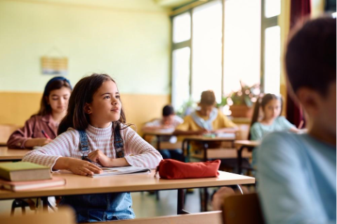 A young Hispanic student listens attentively in class. 